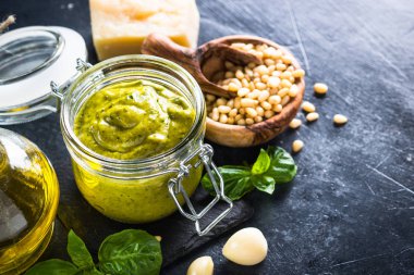 Pesto sos. Fesleğen, zeytinyağı, çam fıstığı, parmesan ve siyah taş masada sarımsak.
