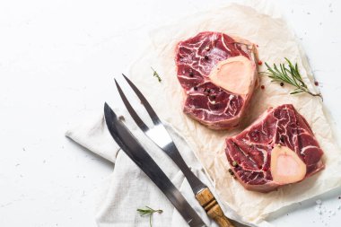 Ham sığır eti biftek osso bucco. Mermer et. Beyaz masa üzerinde kopya alanı ile Üstten Görünüm.