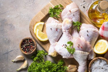 Baharat ve otlar ile kesme tahtası üzerinde tavuk sopaları. Çiğ gıda yemek için hazır. Üstten Görünüm kopya alanı.