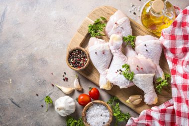 Baharat ve otlar ile kesme tahtası üzerinde tavuk sopaları. Çiğ gıda yemek için hazır. Üstten Görünüm kopya alanı.