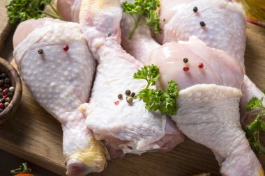 Çiğ tavuk sopaları ile yemek pişirmek için malzemeler kesme tahtası üzerinde.