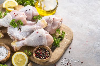 Çiğ tavuk sopaları ile yemek pişirmek için malzemeler kesme tahtası üzerinde.