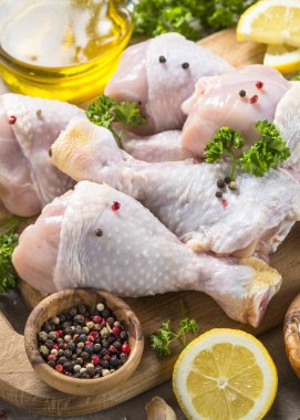 Çiğ tavuk sopaları ile yemek pişirmek için malzemeler kesme tahtası üzerinde.