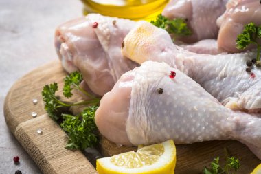 Çiğ tavuk sopaları ile yemek pişirmek için malzemeler kesme tahtası üzerinde.