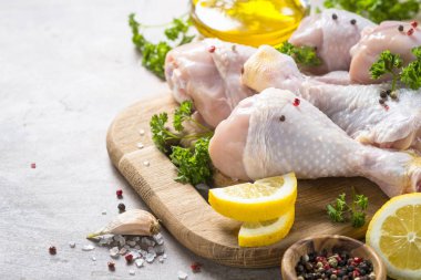 Çiğ tavuk sopaları ile yemek pişirmek için malzemeler kesme tahtası üzerinde.