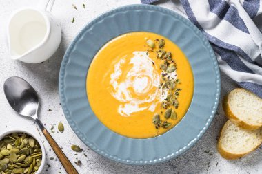 Taş masa lambası üzerinde kabak kremalı çorba.