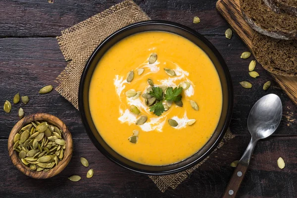 Soupe à la crème de citrouille sur table en bois sombre . — Photo