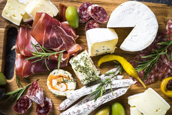 Antipasto bord met gesneden vlees, ham, salami, kaas, olijven een — Stockfoto