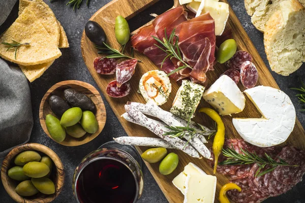 Antipasto-Brett mit Scheiben Fleisch, Schinken, Salami, Käse, Oliven und — Stockfoto