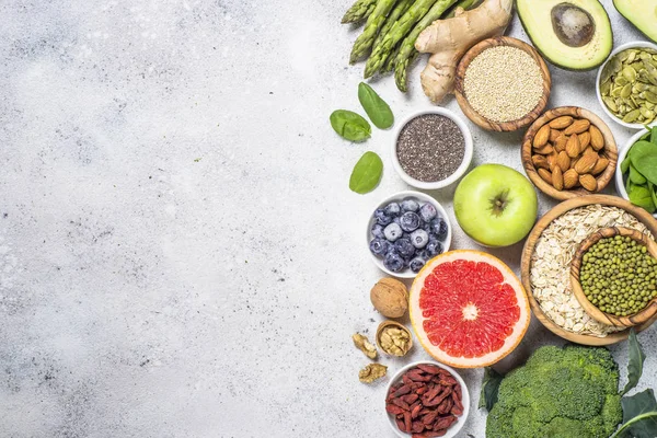 Superfoods på ljus sten bakgrund. Hälsosam vegansk mat. — Stockfoto