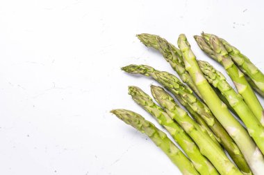 Beyaz arka planda taze yeşil kuşkonmaz.