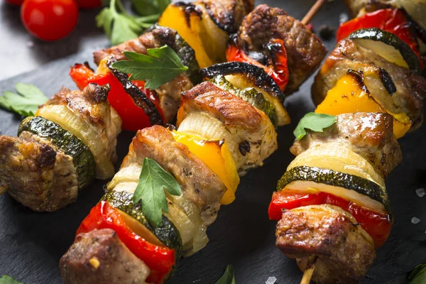 Shish kebab alla griglia con verdure su nero . — Foto Stock