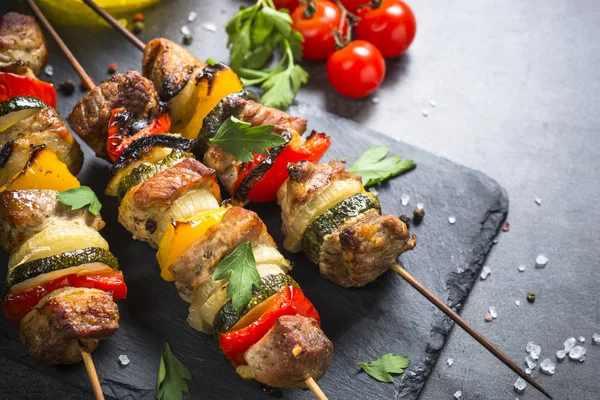 Shish kebab alla griglia con verdure su nero . — Foto Stock