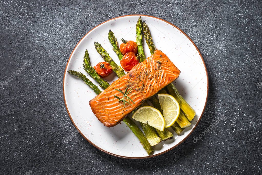 Baked salmon fish fillet with fresh salad top view.