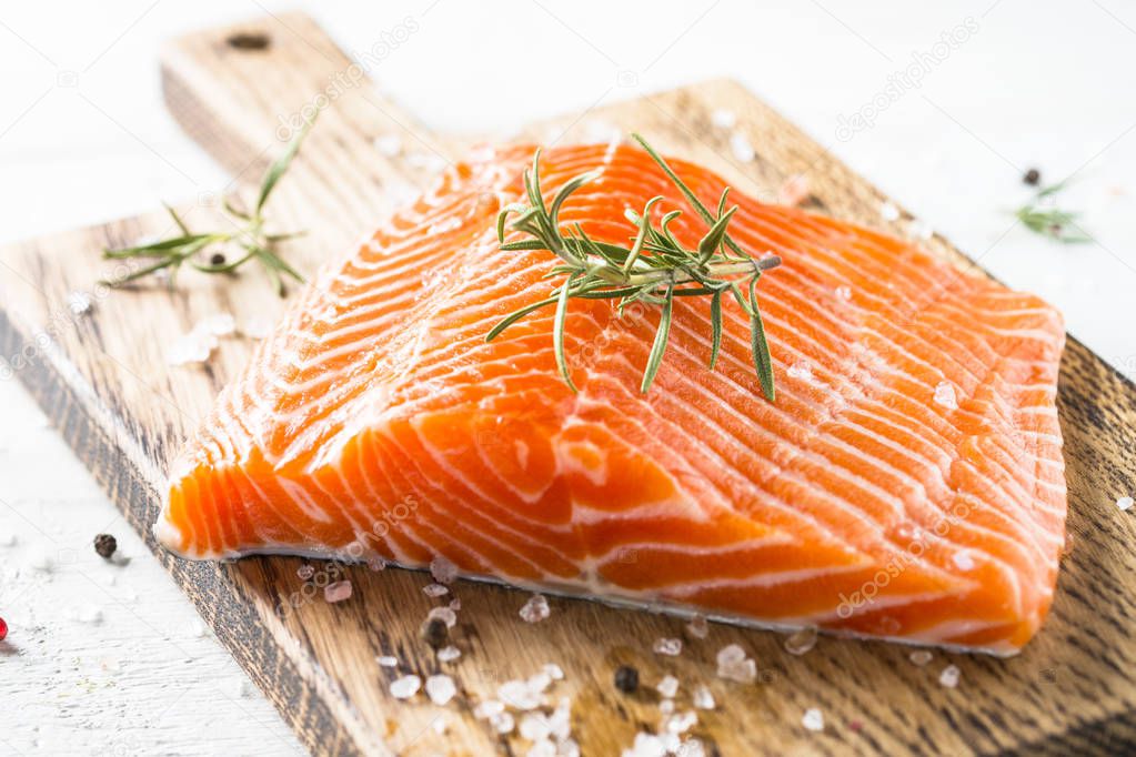 Uncooked salmon fillet with lemon sea salt and rosemary on white
