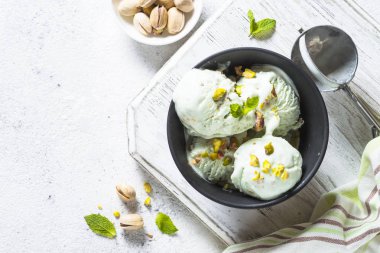 Antep fıstığı dondurma kase beyaz taş masada.