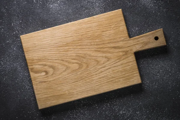 黒い石のテーブルの上で木製のまな板の空. — ストック写真