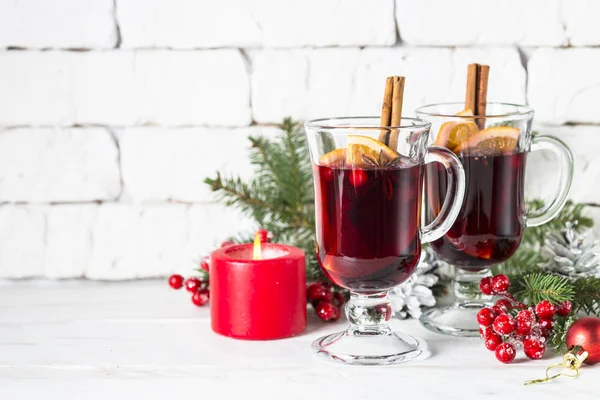 Mulled wine in glass mug with fruit and spices on white. — Stock Photo, Image