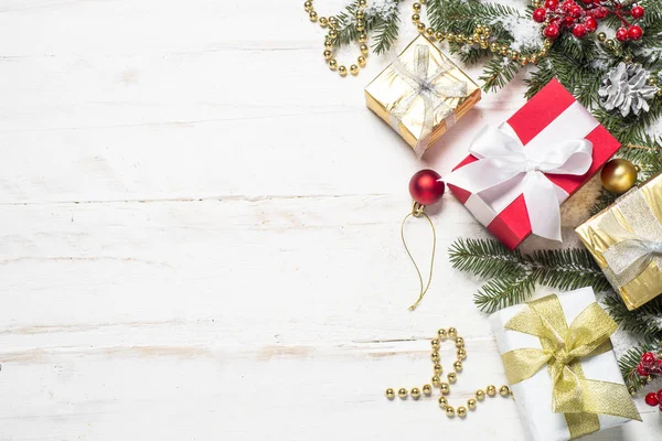 Rot-goldene Geschenkschachtel und Dekorationen auf weißem Holzboden — Stockfoto