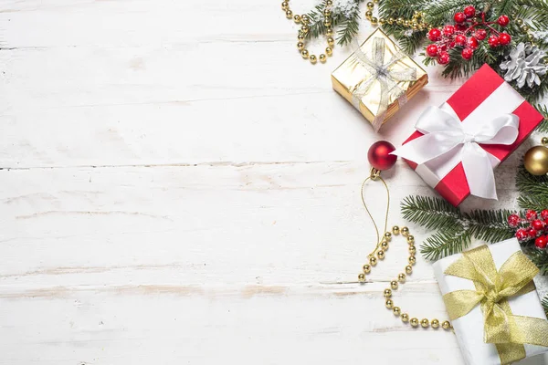 Caja regalo rojo y oro y decoraciones en fondo de madera blanco — Foto de Stock
