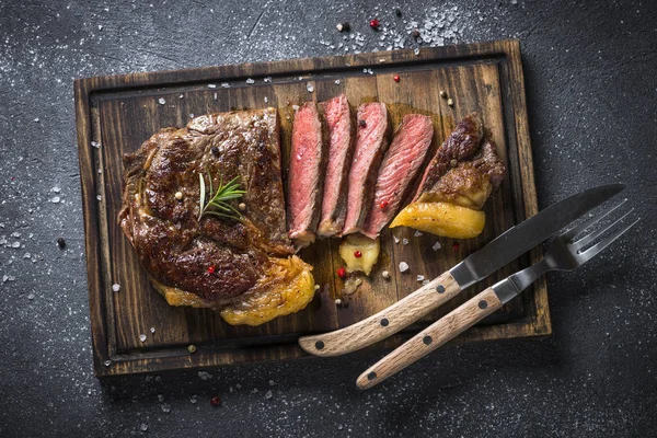 Bife grelhado ribeye em tábua de corte de madeira . — Fotografia de Stock