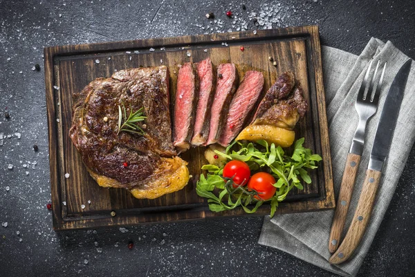 Bife grelhado ribeye em tábua de corte de madeira . — Fotografia de Stock