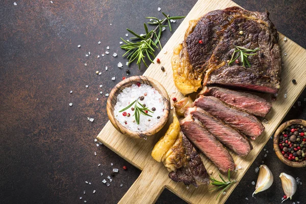 Grilovaný hovězí ribeye steak na dřevěném prkénku. — Stock fotografie