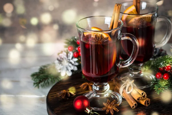 Mulled wine in glass mug with fruit and spices.