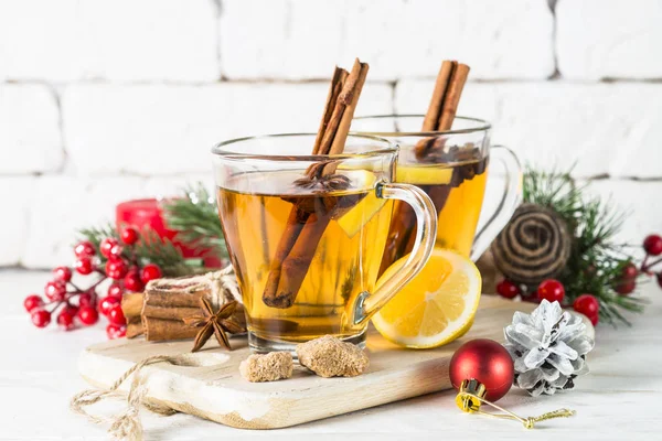 Christmas hot tea with lemon, spices and decorations — Stock Photo, Image