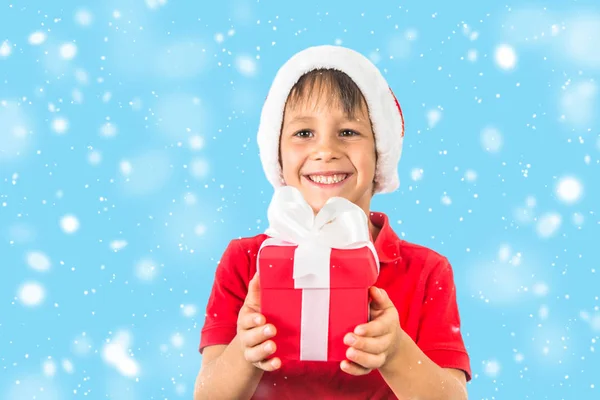 Niño niño en el sombrero de Navidad de Santa y caja de regalo roja en blanco . —  Fotos de Stock