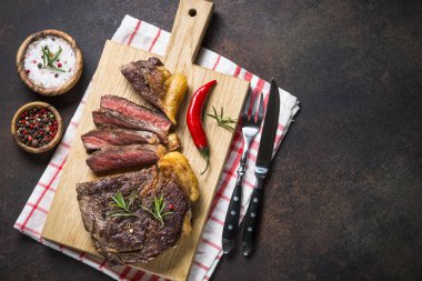 Izgara Dana biftek antrikot ahşap kesme tahtası üzerinde. 