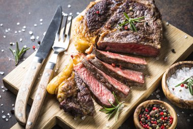 Izgara Dana biftek antrikot ahşap kesme tahtası üzerinde. 