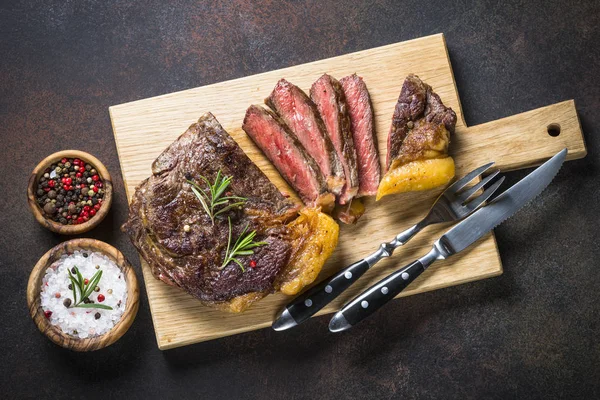 Izgara Dana biftek antrikot ahşap kesme tahtası üzerinde. 