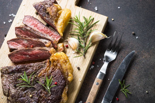 Grilovaný hovězí ribeye steak na dřevěném prkénku. — Stock fotografie