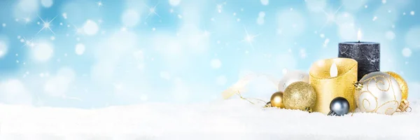 Weihnachten Hintergrund - Kerze und Dekorationen im Schnee auf blau verschwommenem Hintergrund. — Stockfoto