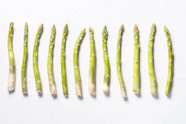 Beyaz arka planda taze yeşil kuşkonmaz.