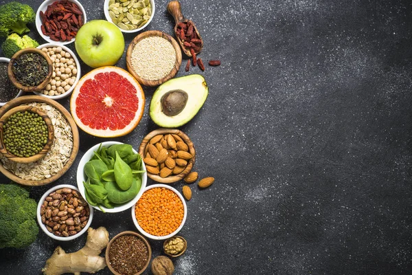 Superalimentos em fundo de pedra preta . — Fotografia de Stock