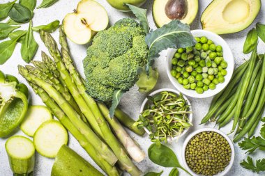 Işık taş zemin üzerine yeşil yiyecek çeşitler. 