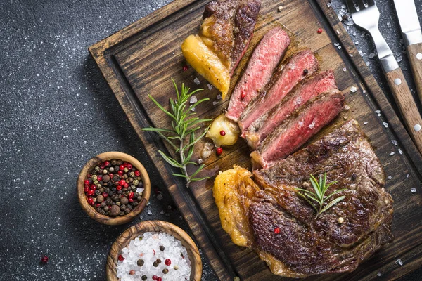Grilovaný Hovězí Steak Ribeye Středně Propečený Dřevěném Prkénku Černém Pozadí — Stock fotografie