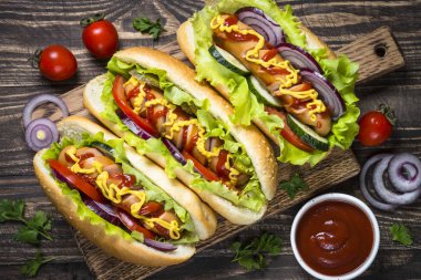 Sosisli sandviç ahşap masa üzerinde taze sebze ile.