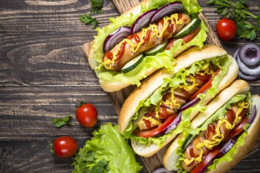 Sosisli sandviç ahşap masa üzerinde taze sebze ile.