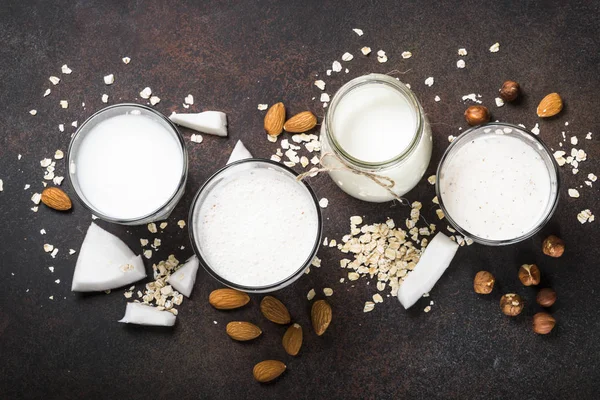 Vegan non dairy alternative milk, nuts and oat milk top view. — Stock Photo, Image
