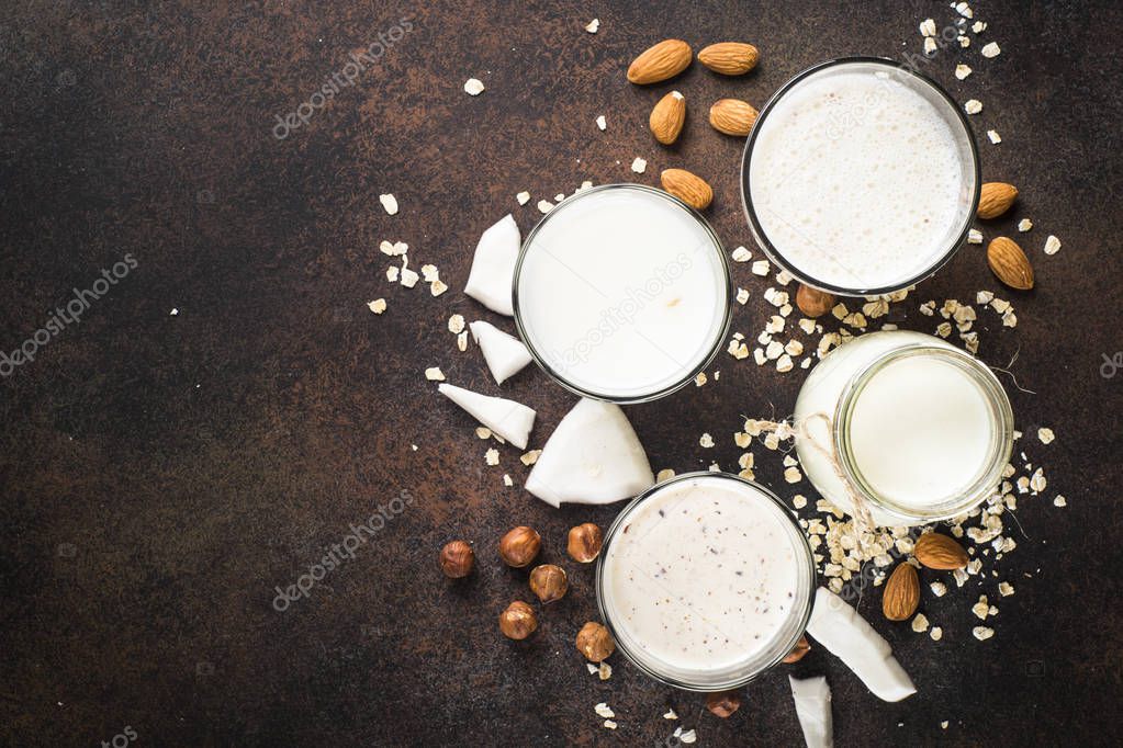 Vegan non dairy alternative milk, nuts and oat milk top view. 