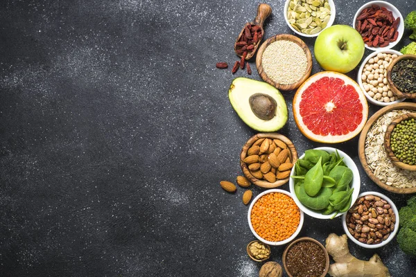 Superalimentos sobre fondo de piedra negra . — Foto de Stock