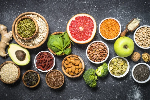 Superfoods op zwarte stenen achtergrond. — Stockfoto