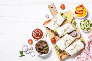 Sığır eti ve sebze üzerinde beyaz backgr ile burrito tortilla saran