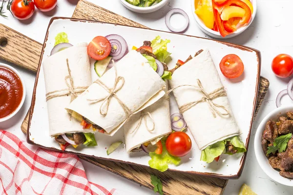 Burritos envolturas de tortilla con carne de res y verduras sobre fondo blanco —  Fotos de Stock