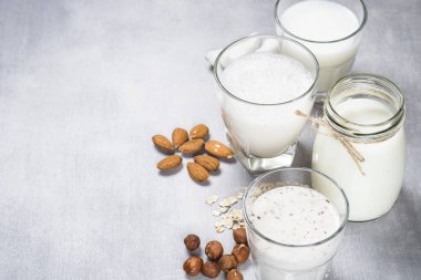 Vegan sigara süt alternatif süt. Hindistan cevizi, badem, fındık, yulaf ev yapımı süt taş masada.