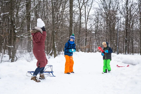 Winterfamilie spielt Schneebälle im Freien. — Stockfoto