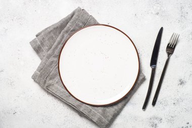 Beyaz zanaat tabak, çatal ve peçete beyaz taş masada. 